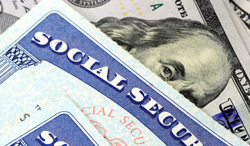 social security card over a stack of American money